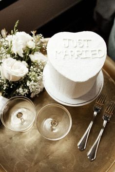 a wedding cake and silverware on a tray