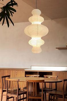 a dining room table with four chairs and a light fixture hanging from the ceiling