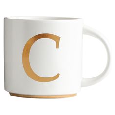 a white and gold coffee mug with the letter c on it