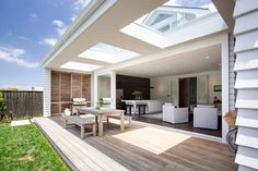 an outdoor living area with wooden decking and white furniture