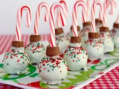 candy canes and marshmallows are arranged on a red and green plate