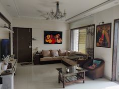 a living room filled with furniture and a chandelier hanging over it's windows