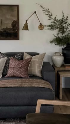 a living room filled with lots of furniture next to a wall mounted painting on the wall