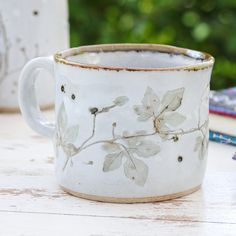 a white coffee cup sitting on top of a wooden table