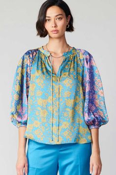 A split neckline, billowy sleeves, and colorblocked floral print are the defining characteristics of this breezy popover blouse. Cut for a loose silhouette, the style floats against the body and finishes with dainty tie detailing. •Split neckline with self-tie •Three-quarter sleeves •Relaxed fit Item number 2330075-2 100% Polyester Hand wash Styling Floral Tops, Printed Tops For Women, Ladies Printed Tops, Western Blouse, Coord Sets, Winter Blouses, Billowy Sleeves, Cotton Shirts Women, Happy Woman