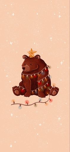 a brown bear sitting on top of a christmas tree