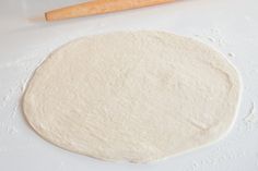 the dough is ready to be made into pizza crusts with a rolling pin in the background