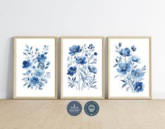 three blue flowers are on the wall next to each other in front of a wooden floor