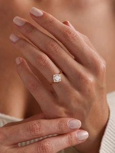 a woman's hand with a diamond ring on it