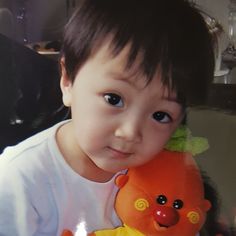 a little boy holding a teddy bear in his arms