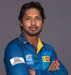 a man with his arms crossed wearing a blue shirt