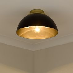 a light that is on in the corner of a room with white walls and ceiling