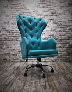 a blue office chair sitting in front of a brick wall with wheels on the base