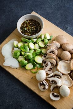 mushrooms, brussel sprouts and other vegetables on a cutting board