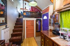 the inside of a house with stairs and green curtains