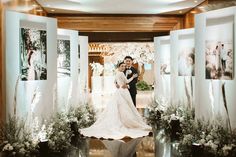 a bride and groom are standing in front of their wedding photos at the ceremony venue