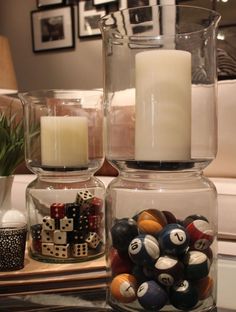 two glass vases with candles and balls in them