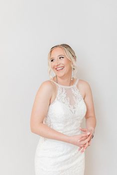 a woman in a white dress is posing for a photo with her hands on her hips