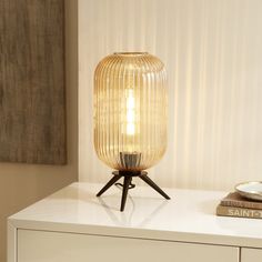 a table lamp sitting on top of a white dresser