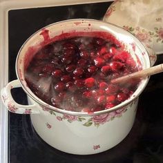 a pot filled with cranberry sauce on top of a stove