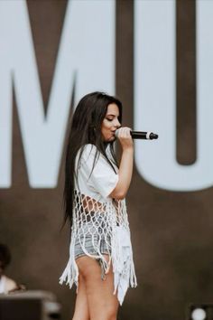 a woman standing on top of a stage holding a microphone