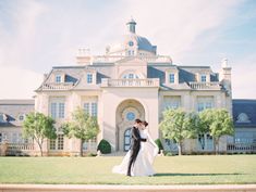 a bride and groom standing in front of a large building