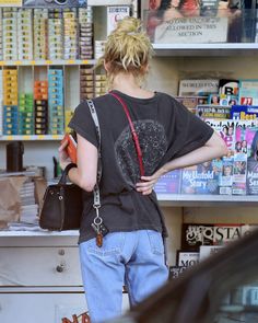 a woman standing in front of a book store with her back turned to the camera