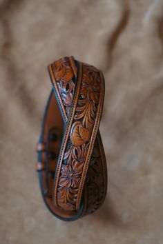 All of our Hand Tooled Belts are made one at a time in our shop by Clint Wilkinson. Craftsmanship of this nature takes a tremendous amount of time, so please be patient. Sizing (Please read carefully) Best Results: Take your old belt and measure from leather "fold" (A) to the current hole you're using (B). The results in inches will be the belt size you need to order. Alternative: Take your waist size in pants and add 2 inches, this will be the belt size you need to order Watch Video On Belt Mea Carved Leather Belt, Hand Tooled Leather Belt, Tooled Belts, Cowboy Outfit For Men, Tooled Belt, Cowboy Outfit, Tooled Leather Belts, Belt Holster, Cowboy Outfits