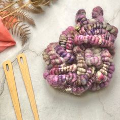 a pile of yarn next to a pair of scissors on top of a white table