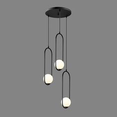 three lights hanging from the ceiling in a dark room with grey walls and flooring