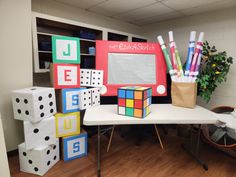 an office cubicle with dices, markers and pencils on the table in front of it