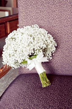 a bouquet of white flowers sitting on top of a purple couch