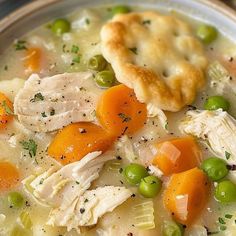 a bowl of chicken pot pie soup with peas and carrots