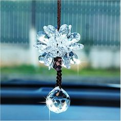 a car dashboard hanging from the side of it's windshield with some crystal beads on it