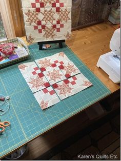 the table is covered with quilts and scissors