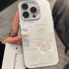 someone is holding up their phone case with an image of a butterfly on the back