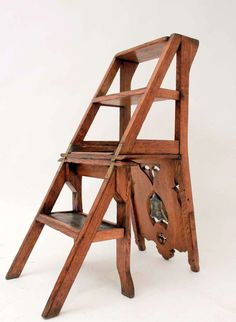 an old wooden step ladder with wheels on it