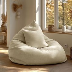 a bean bag chair sitting on top of a hard wood floor next to a window