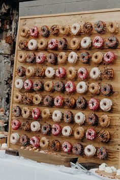 there are many donuts on the wooden board