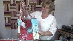 a woman holding onto a bag made from patchwork material