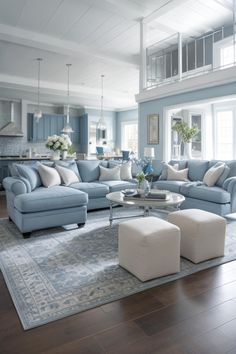 a living room filled with blue couches and white pillows on top of a wooden floor