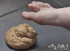 a hand reaching for a cookie on the ground