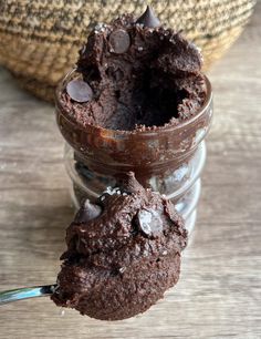 a spoon full of chocolate ice cream on top of a wooden table