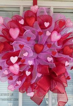 a heart mesh wreath hanging on the front door for valentine's day decorating