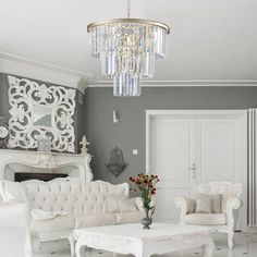 a living room filled with white furniture and a chandelier