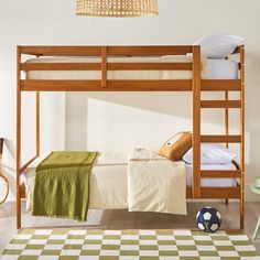 a bunk bed in a room with a checkered rug and soccer ball on the floor