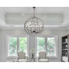 a chandelier hanging from the ceiling in a room with two chairs and a table