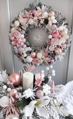 a wreath with pink and white ornaments on it