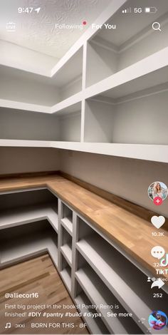 a walk in closet with white shelving and wood flooring on the bottom shelf