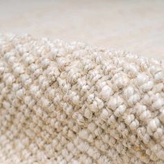 a close up view of the texture of a rug with white and beige colors on it